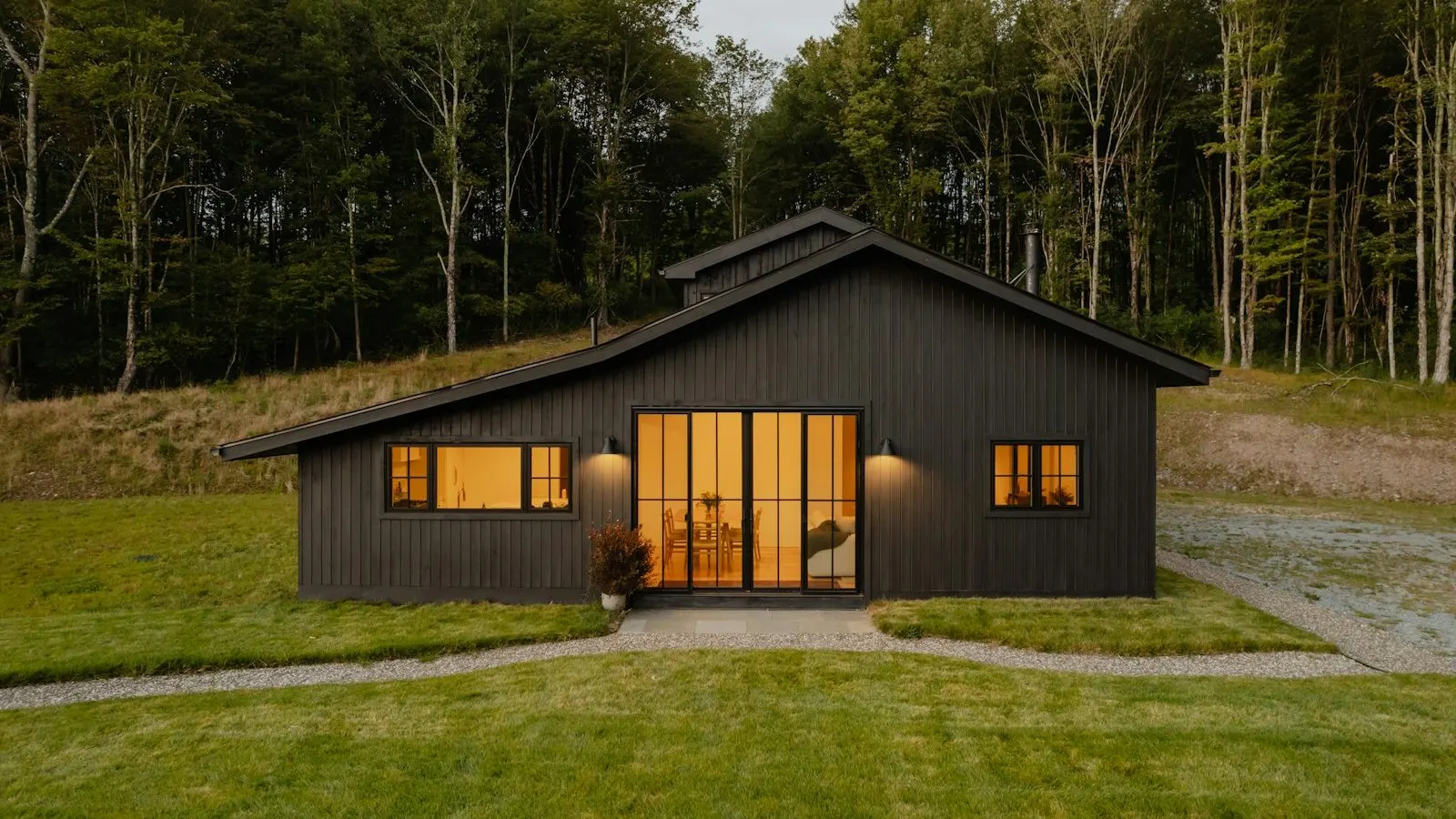 Modern home exterior with slim black aluminum-frame windows and doors