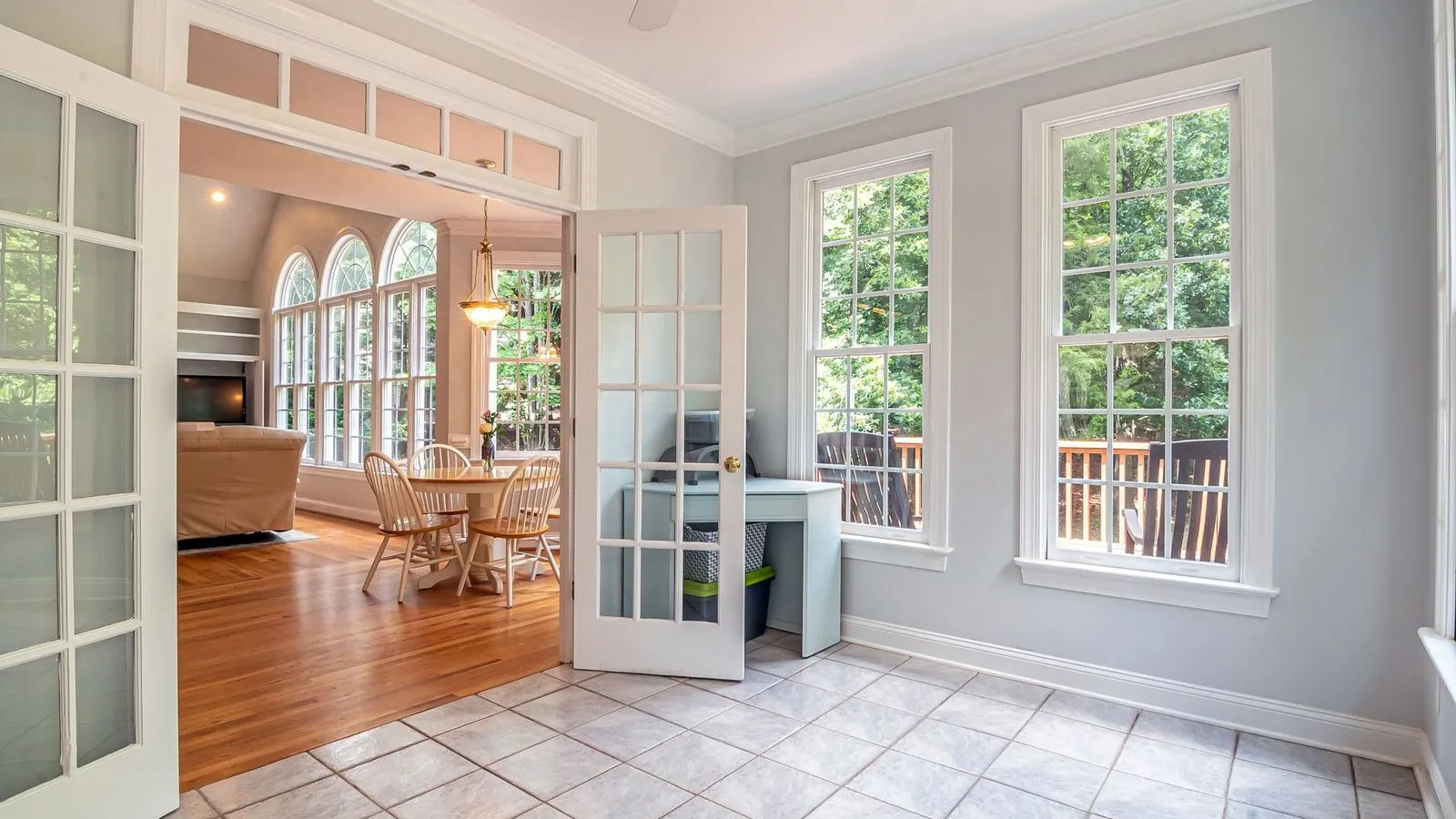 Traditional white French doors with multi-pane glass opening between rooms