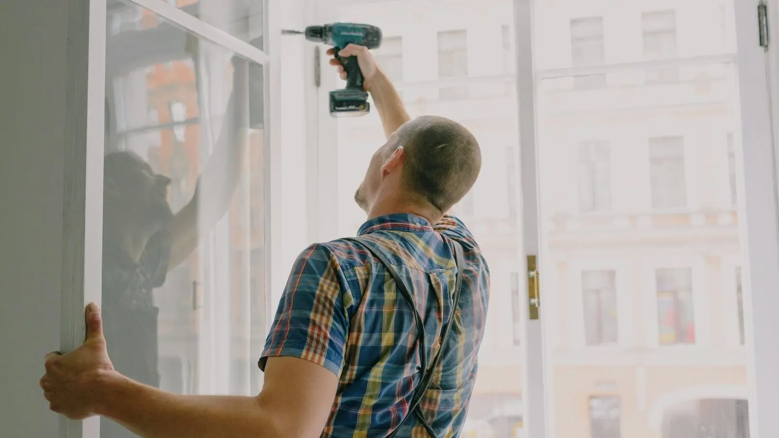 Installer fitting a replacement window frame during a retrofit installation